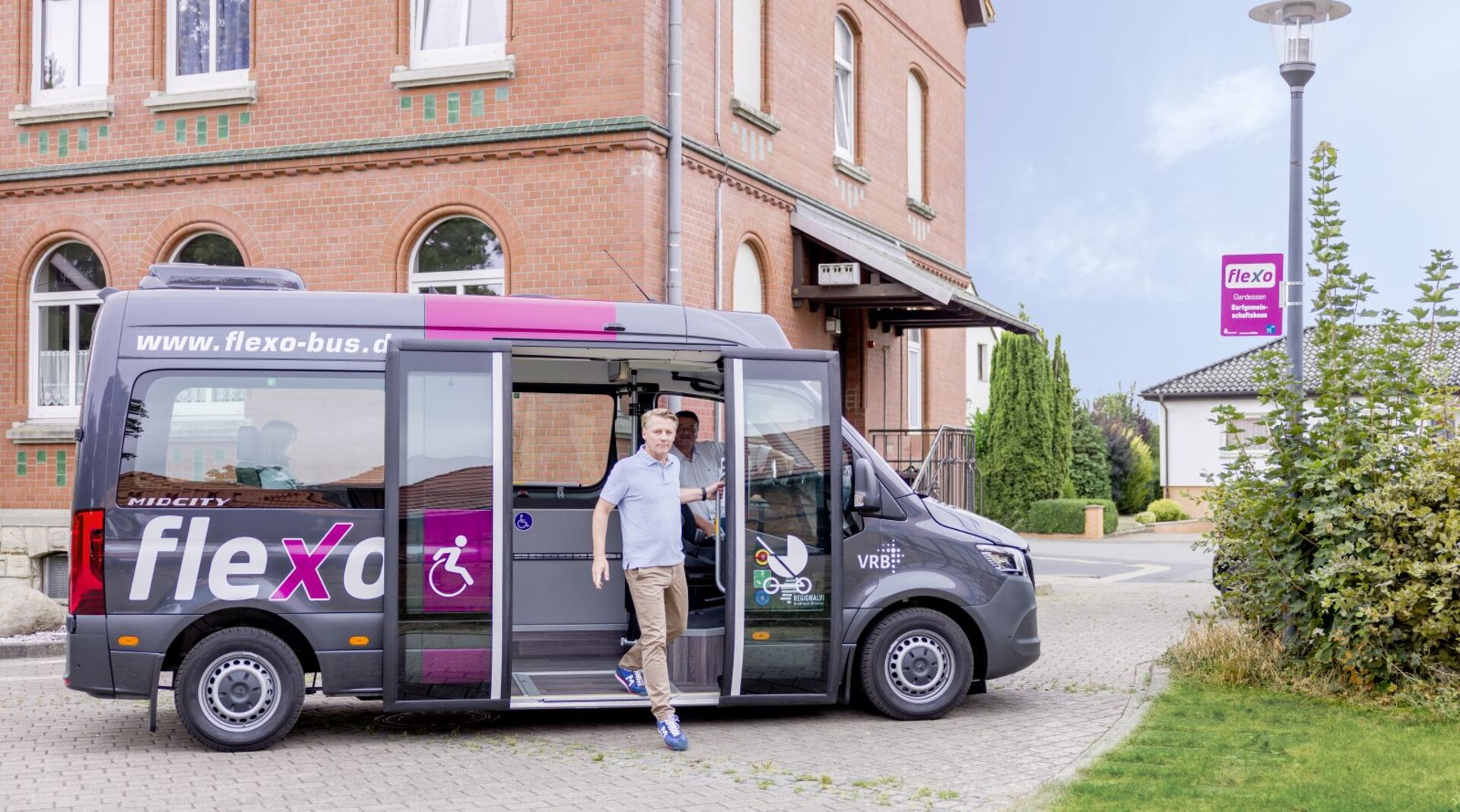 Ein Mann steigt aus einem flexo Bus aus.