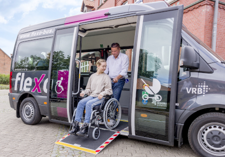 Eine Frau im Rollstuhl wird in den flexo Bus geschoben