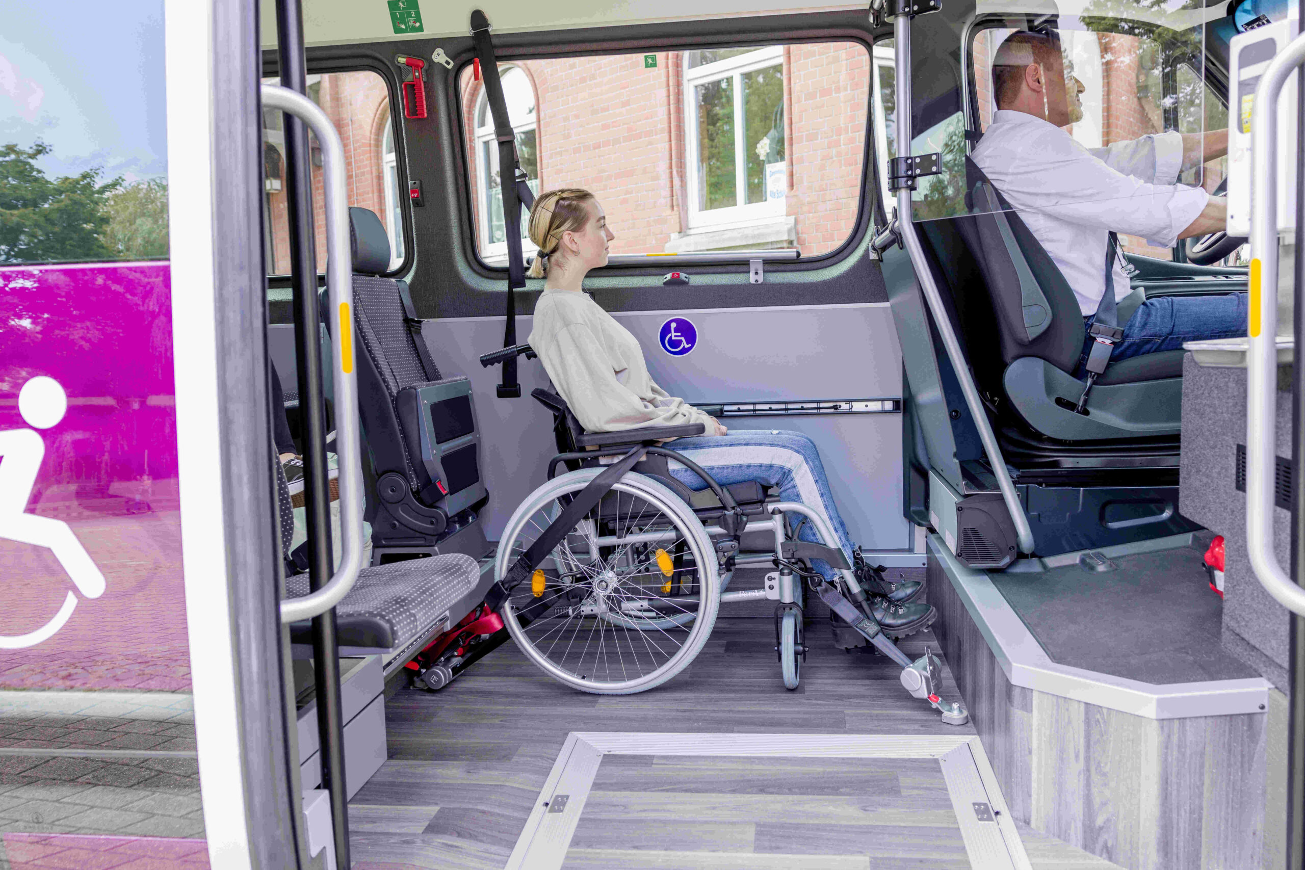 Frau sitzt im angeschnallten Rollstuhl im flexo Bus